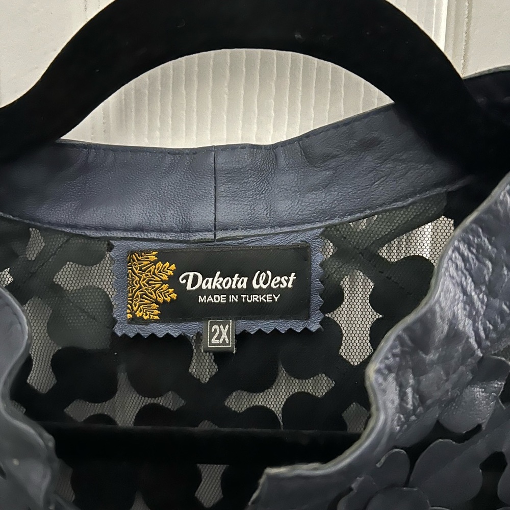 This is a stylish, navy blue leather jacket for a woman.